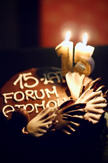 Tort z napisem „15 lat FORUM ATOMOWE” i zapalonymi zimnymi ogniami