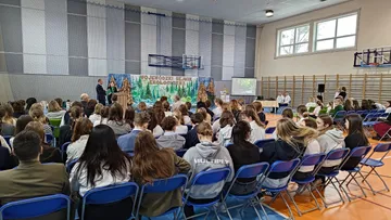 Uczniowie na widowni w sali gimnastycznej podczas Wojewódzkiego Sejmiku Ekologicznego