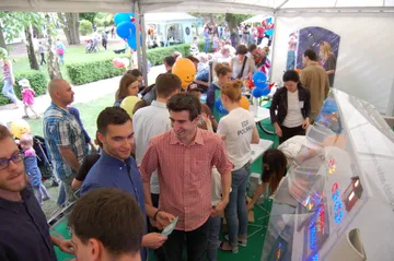 Zwiedzający przy stoisku w ogrodzie ambasady