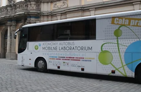 Biały Atomowy Autobus przed zabytkową kamienicą