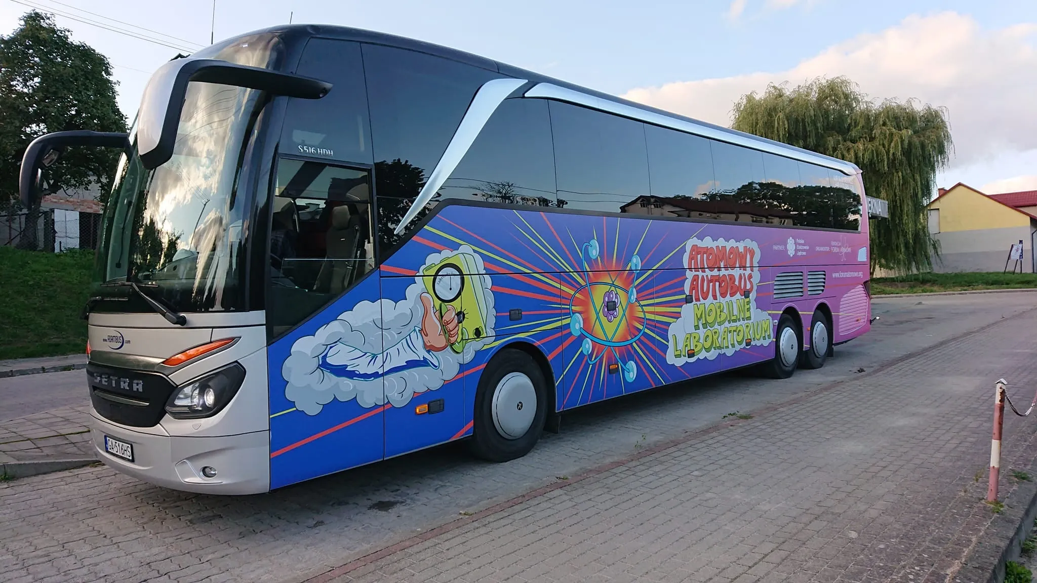 Fioletowy Atomowy Autobus na parkingu przy szkole