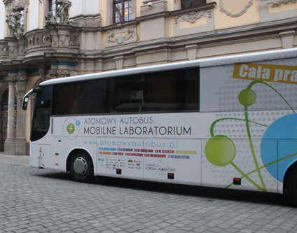 Biały Atomowy Autobus – Mobilne Laboratorium przed zabytkowym budynkiem