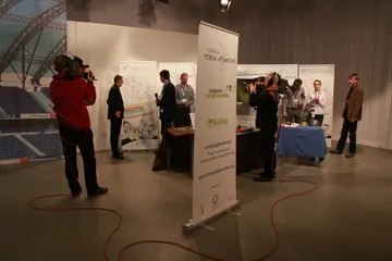 Ekipa telewizyjna nagrywa przy stoisku z roll-upami Fundacji w hali