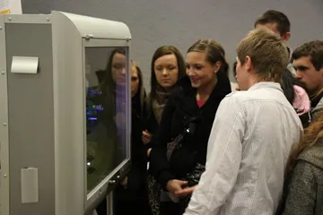 Studenci oglądają eksponat w gablocie