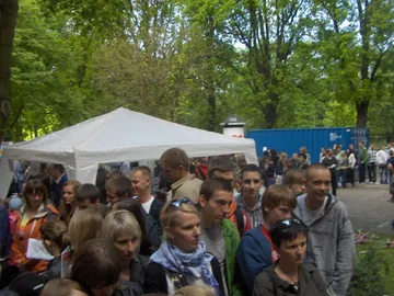 Tłum zwiedzających czeka w kolejce przy namiotach festiwalu w parku