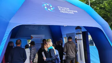 Zwiedzający w niebieskim namiocie Polskich Elektrowni Jądrowych