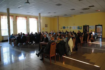 Duża sala pełna uczestników siedzących przy stołach