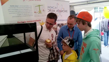 Osoba z Fundacji rozmawia z dziećmi przy gablocie