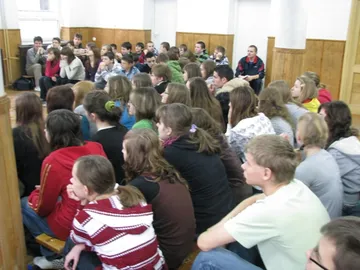Gimnazjaliści słuchają wykładu w zatłoczonej sali