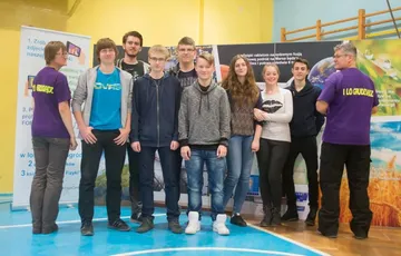 Grupa uczniów pozuje przy planszach Fundacji
