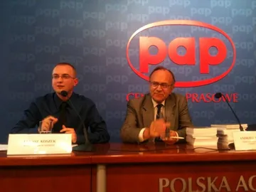 Dwie osoby za stołem konferencyjnym na tle logo PAP podczas konferencji prasowej