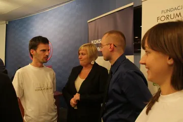 Cztery osoby rozmawiają przy roll-upach Konsorcjum Atomowego i Fundacji