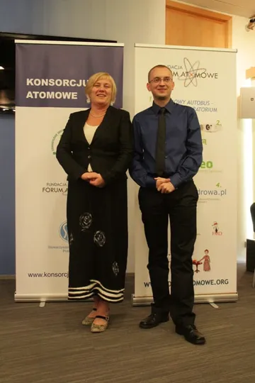Dwie osoby pozują przy roll-upach Konsorcjum Atomowego i Fundacji
