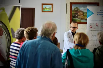 Mieszkańcy przy stoiskach wystawy w świetlicy sołeckiej