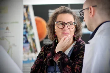 Uczestniczka spotkania słucha objaśnień