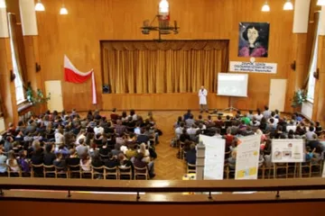 Widok z balkonu na pełną aulę z flagą podczas seminarium