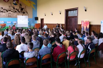 Uczniowie wypełniają szkolną aulę podczas wykładu