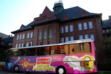 Atomowy Autobus przed ceglanym budynkiem szkoły