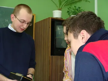 Osoba prowadząca zajęcia pokazuje uczniom miernik promieniowania z bliska