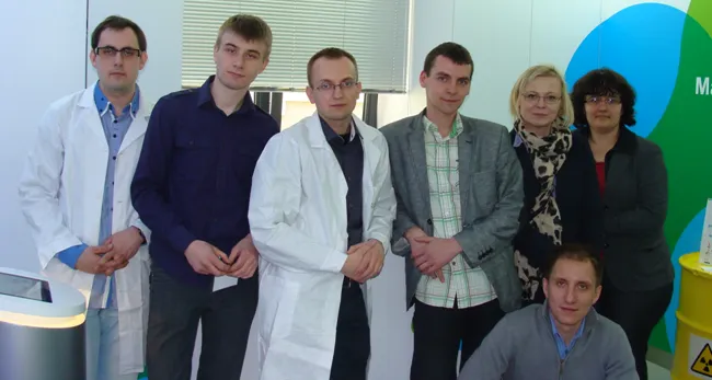 Siedem osób, w tym dwie w białych fartuchach, w lokalnym punkcie informacyjnym „Świadomie o atomie”