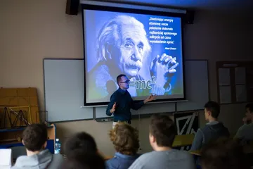 Wykład przed uczniami; na ekranie zdjęcie Alberta Einsteina