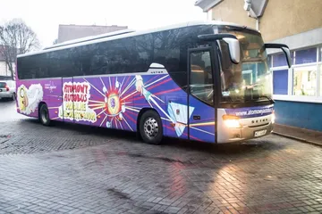 Atomowy Autobus na mokrej ulicy przy szkole