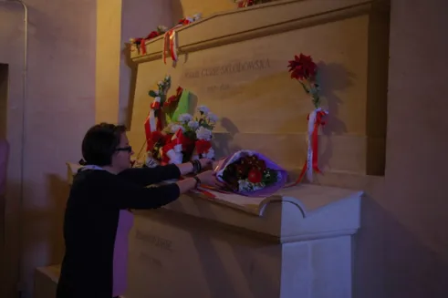 Osoba składa kwiaty przy grobie Marii Skłodowskiej-Curie w paryskim Panteonie