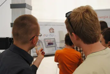 Zwiedzający przy planszy o elektrowni jądrowej z reaktorem wodno-ciśnieniowym