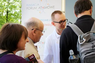 Osoba z Fundacji rozmawia ze starszymi zwiedzającymi