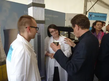 Dwie osoby z Fundacji rozmawiają ze zwiedzającym