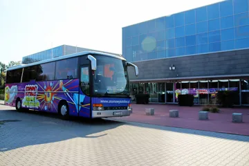 Atomowy Autobus przed przeszklonym budynkiem w Puławach
