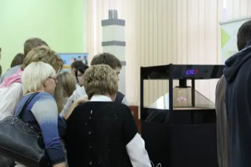 Uczniowie przy gablocie z hologramem