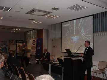 Sala konferencyjna Trzeciej Szkoły Energetyki Jądrowej; przy mównicy osoba przemawiająca