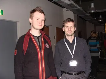 Dwie osoby z identyfikatorami pozują na korytarzu centrum konferencyjnego