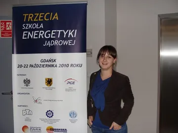 Osoba przy roll-upie „Trzecia Szkoła Energetyki Jądrowej, Gdańsk, 20–22 października 2010 roku”
