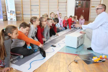 Dzieci przy taśmie z widmem promieniowania elektromagnetycznego
