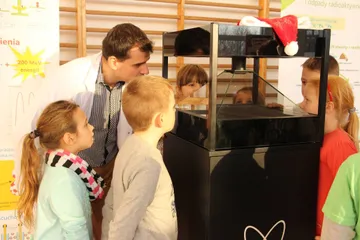 Dzieci zaglądają do gabloty z hologramem