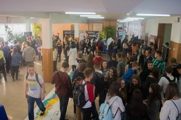 Tłum uczniów na szkolnym korytarzu przy stoiskach Atomowego Autobusu