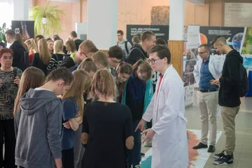 Uczniowie przy taśmie z widmem promieniowania elektromagnetycznego